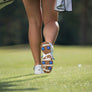 The underside of a persons right golf shoe showing the azue blue pulsar golf spikes attached.