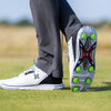 The underside of a persons golf shoe showing the green pivix golf spikes attached. 