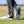 The underside of a persons golf shoe showing the green pivix golf spikes attached.